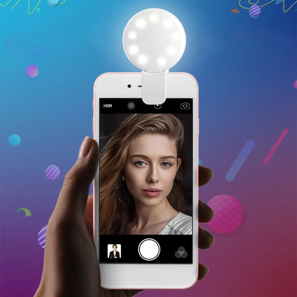 Small round white LED fill light clipped onto a mobile phone for taking selfies.