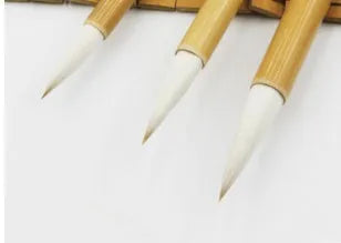 Three Chinese writing brushes with bamboo handles in large medium small sizes