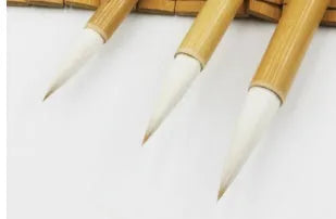 Three Chinese writing brushes with bamboo handles in large medium small sizes