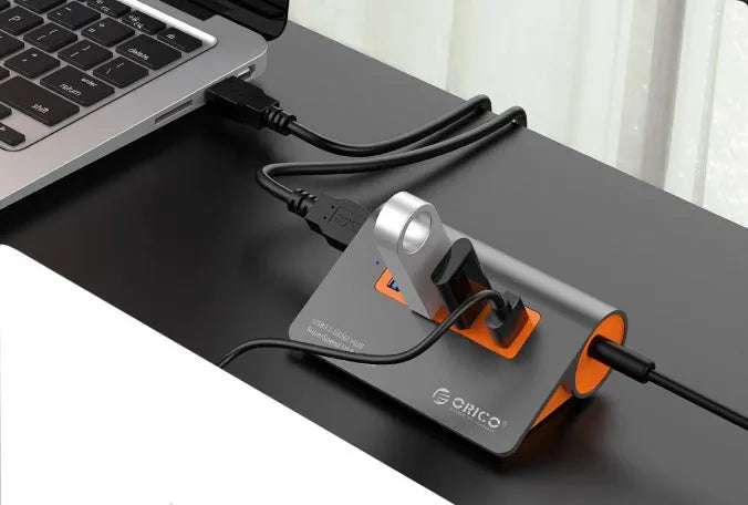 Dark grey USB-C laptop hub with four USB 3.1 ports and orange accents beside its separate 100cm cable