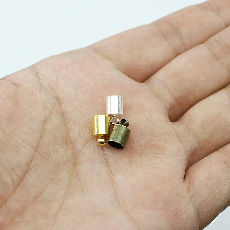 Assortment of small, dome-shaped copper caps in gold, silver, black, and bronze finishes for jewellery making.
