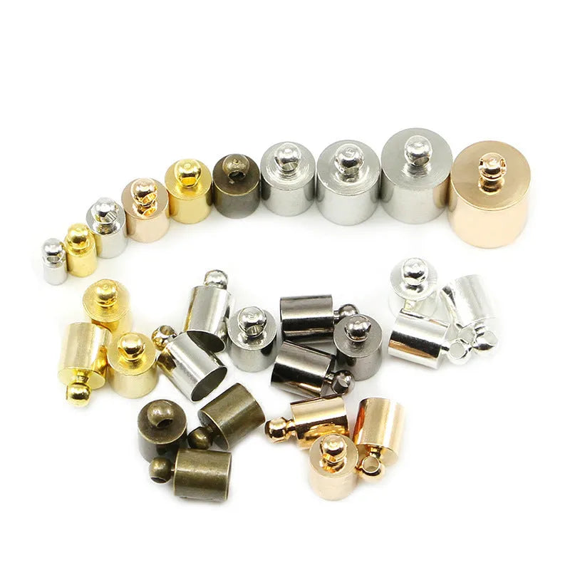Assortment of small, dome-shaped copper caps in gold, silver, black, and bronze finishes for jewellery making.