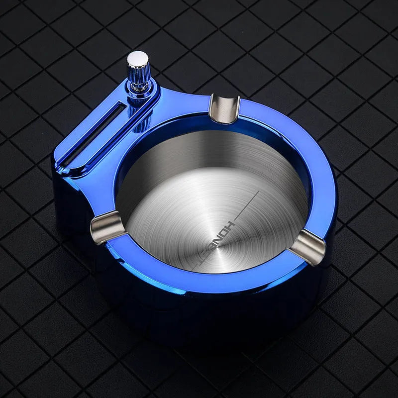 Blue metal ashtray with sliding permanent match lighter and three cigarette slots on a table.