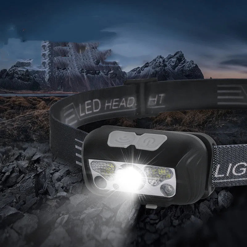 Black USB rechargeable sensor headlight with white and red LED lights on a head strap.