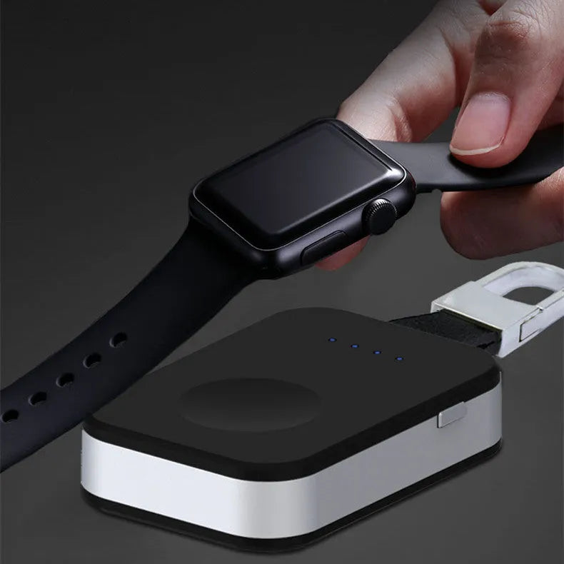 Black Apple Watch portable wireless power bank with keychain ring, shown next to an Apple Watch.