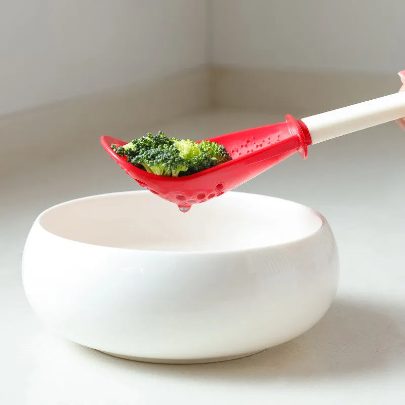 Red and black multifunctional plastic cooking spoon with serrated grinding edge and half-enclosed rice scoop head.