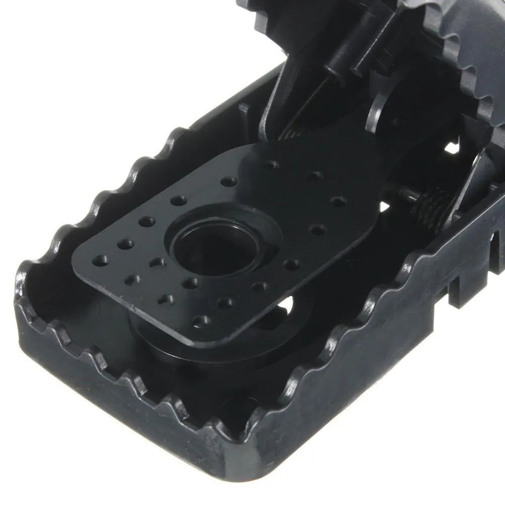 Six black plastic snapping mousetraps showing bite-trap mechanism with ruler showing 11cm length