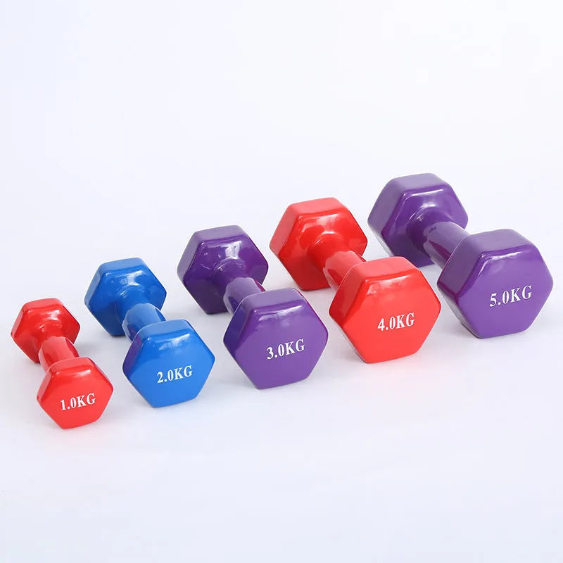 A set of bright colourful plastic dumbbells in different sizes on a light floor.