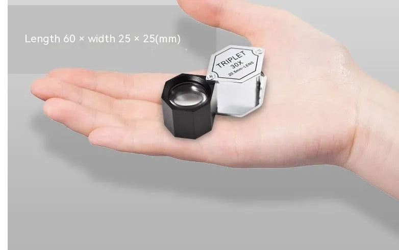 Handheld portable magnifying glass with metal body and optical glass lens for jewellery and coin inspection.