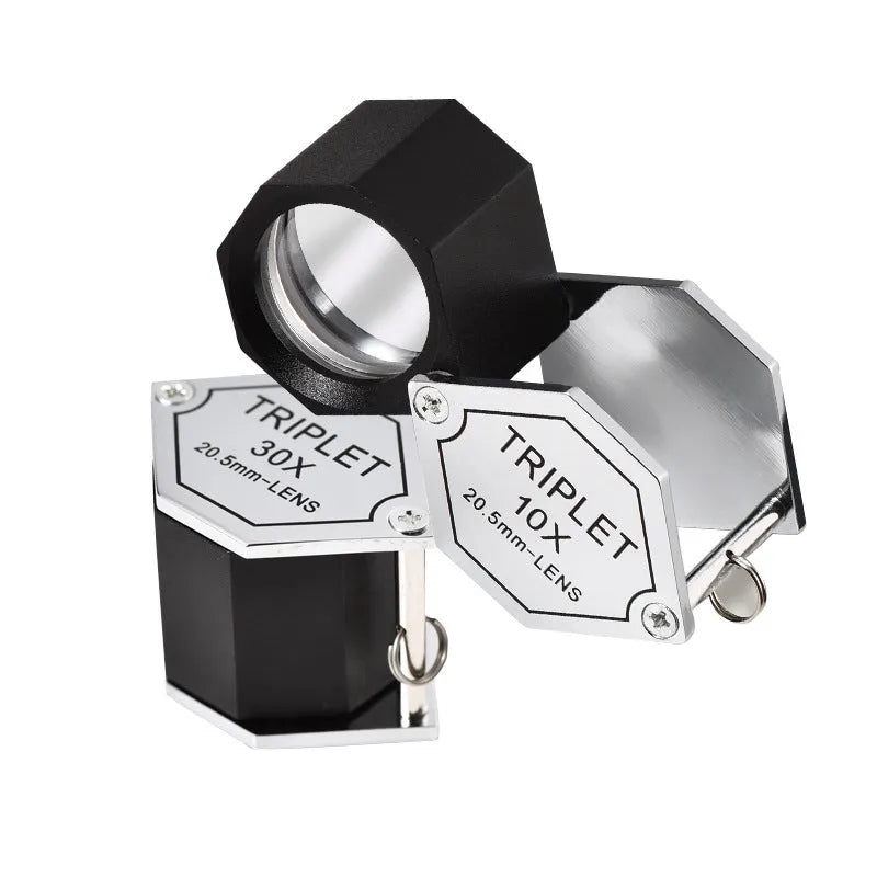 Handheld portable magnifying glass with metal body and optical glass lens for jewellery and coin inspection.