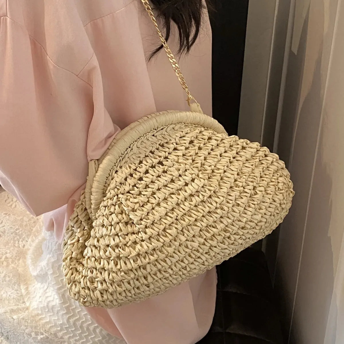Women's shell-shaped straw shoulder bag with chain strap in khaki colour showing zippered internal pocket