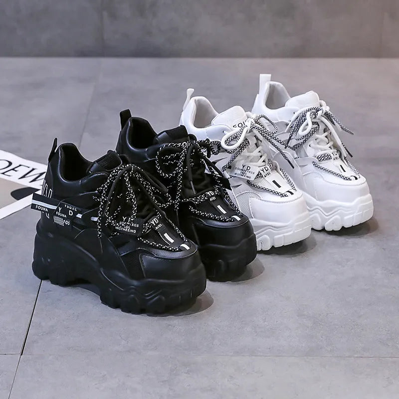 White women's low-top mesh sneakers with a black cross strap and a thick rubber platform sole.