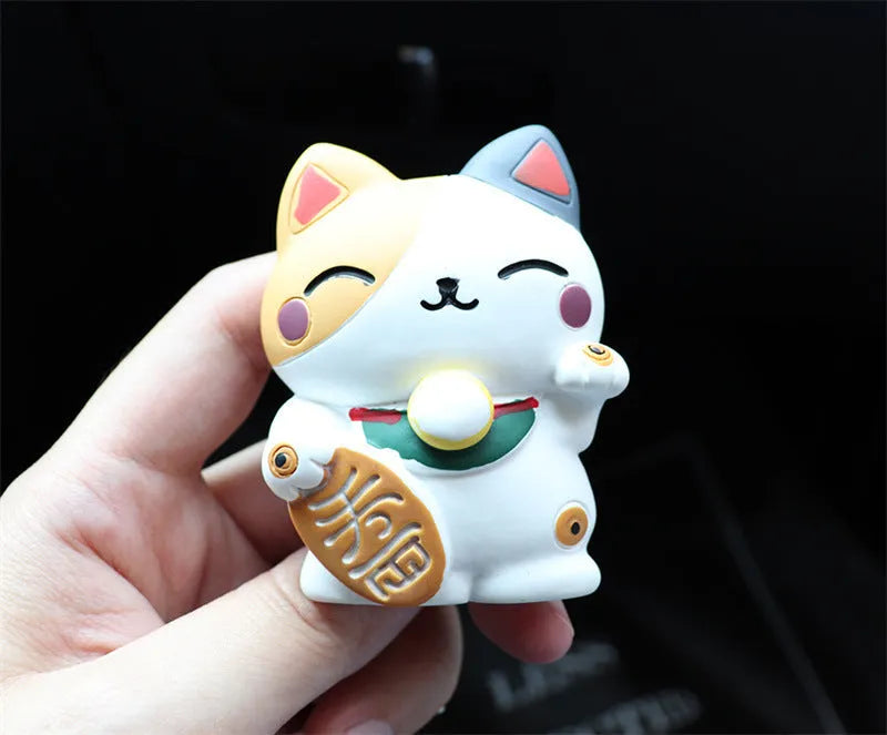 Black and white resin fortune cat decorative clip for car air conditioning vent with aromatherapy function.