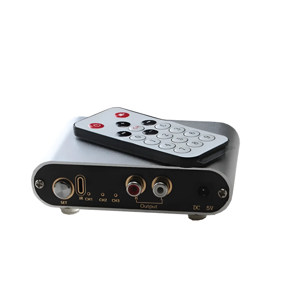 Silver audio source selector switch unit with infrared remote control for routing multiple audio signals.