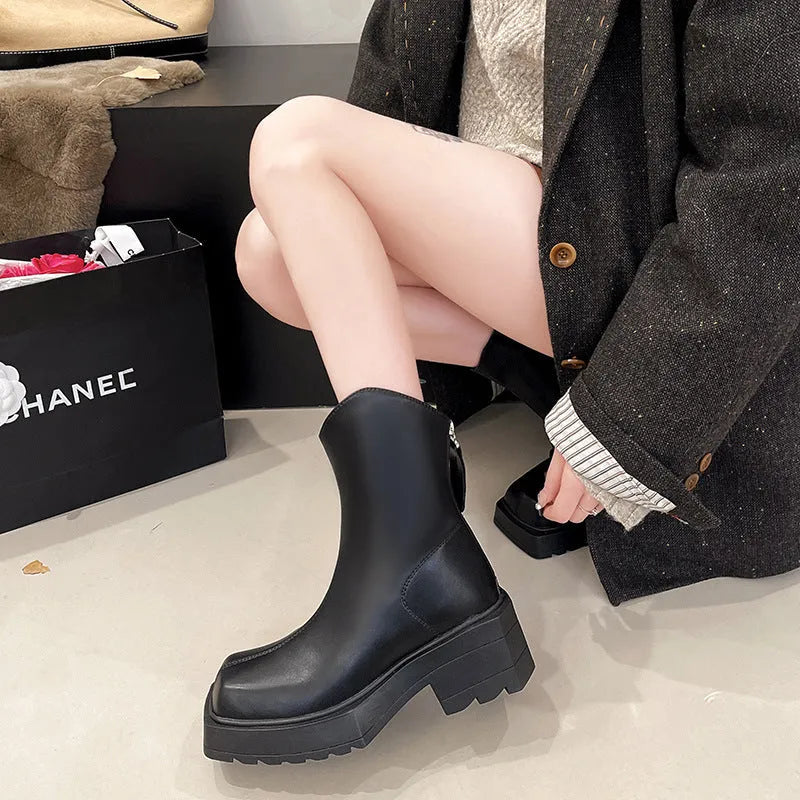 Women's black platform Martin ankle boots with square toe, chunky heel, and back zipper on a plain background.