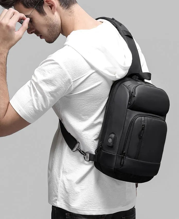 Black medium-sized PVC shoulder bag showing internal organisation pockets and air cushion strap