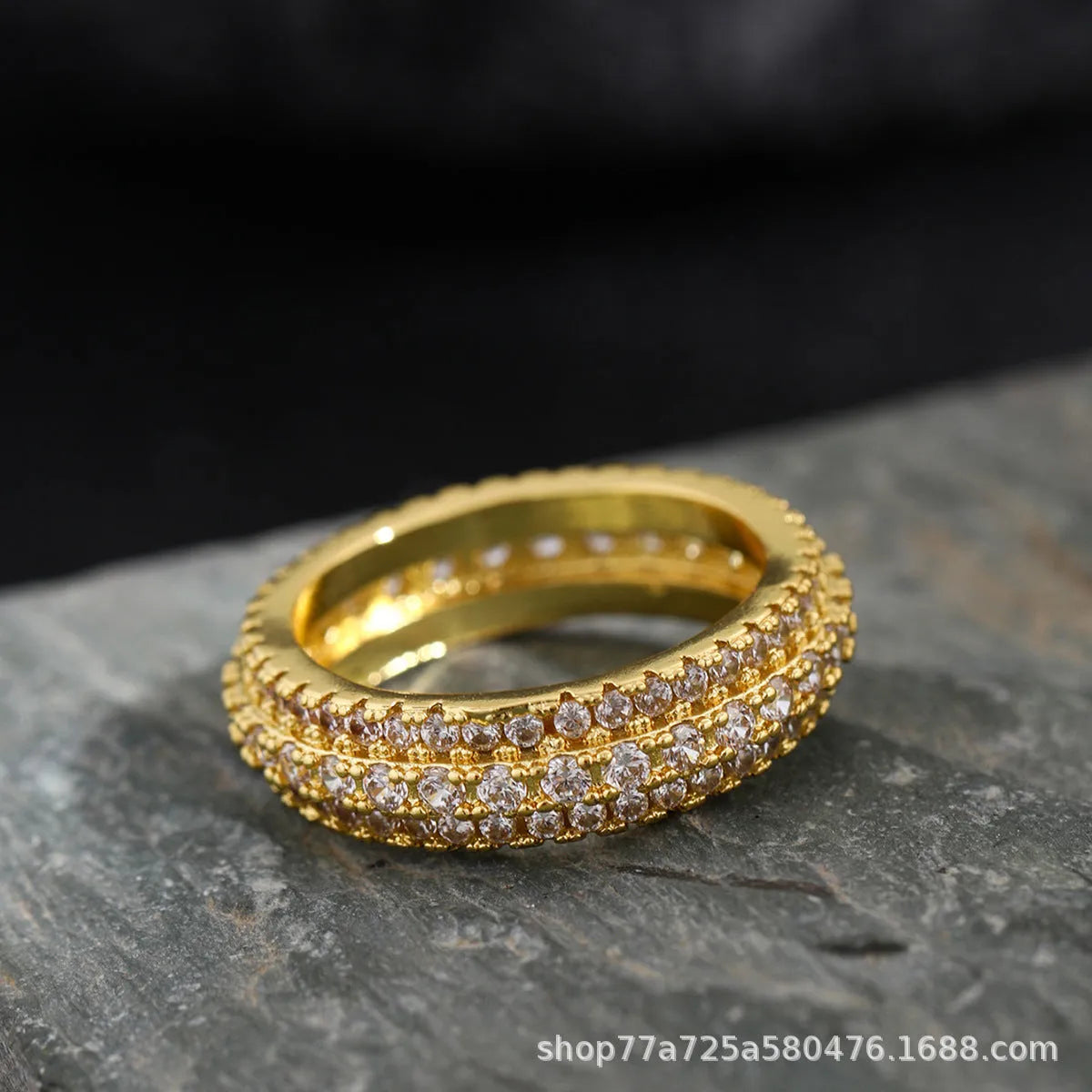 A geometric unisex ring with a triangular zircon stone inlay, shown in white gold, yellow gold and white and black plating finishes.