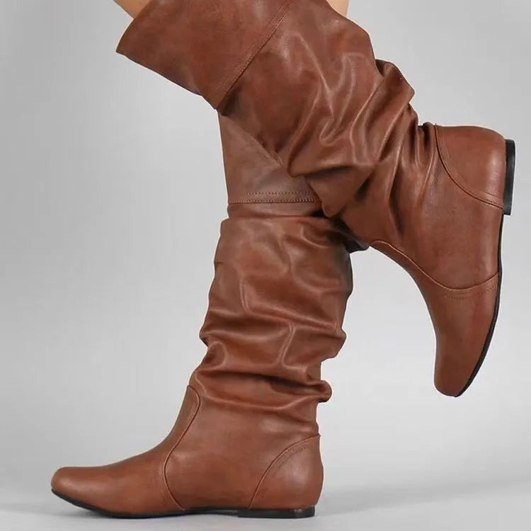 Women's flat heel slip-on ankle boot in artificial PU, shown in a solid colour with a round toe and high-top design.