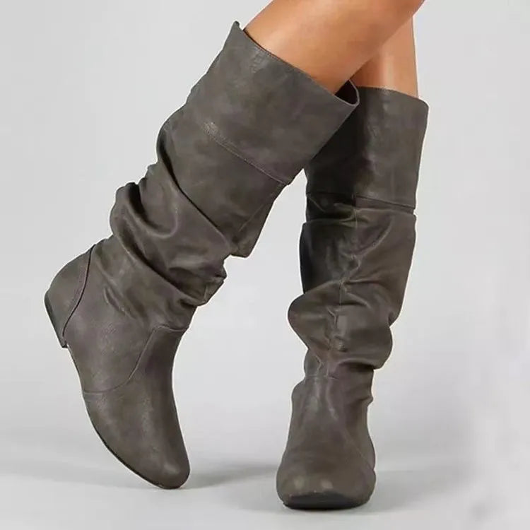 Women's flat heel slip-on ankle boot in artificial PU, shown in a solid colour with a round toe and high-top design.