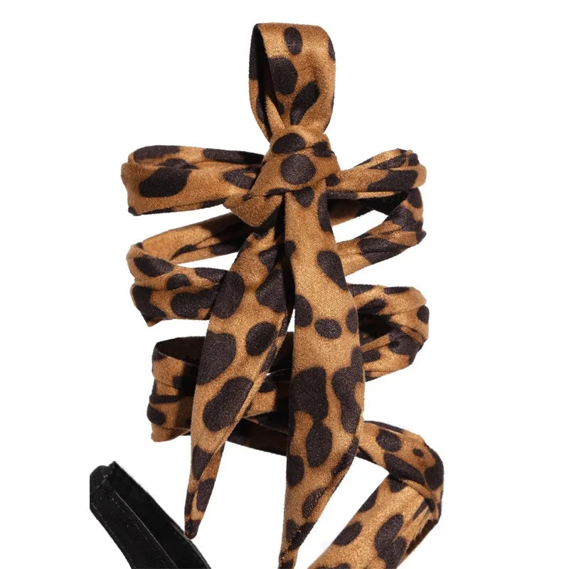 Light brown leopard print women's high heel sandals with criss-cross ankle straps and a pointed toe.