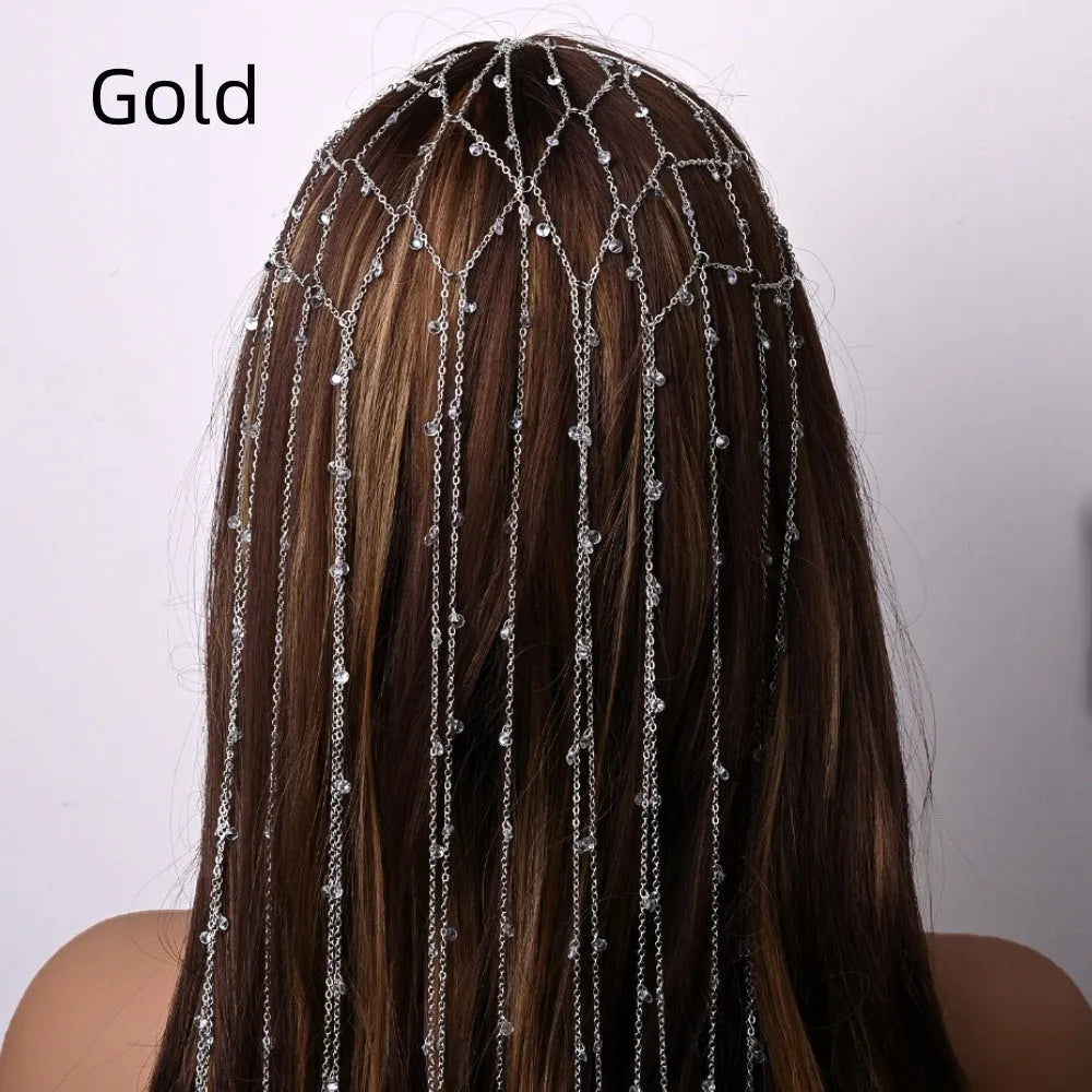Gold coloured mesh headband decorated with rhinestones and a hanging tassel.