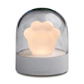 Grey and pink cat paw shaped USB rechargeable night light with music box function on desktop