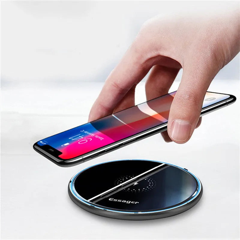 Black or white aluminium alloy wireless charging pad with LED status light on desk.