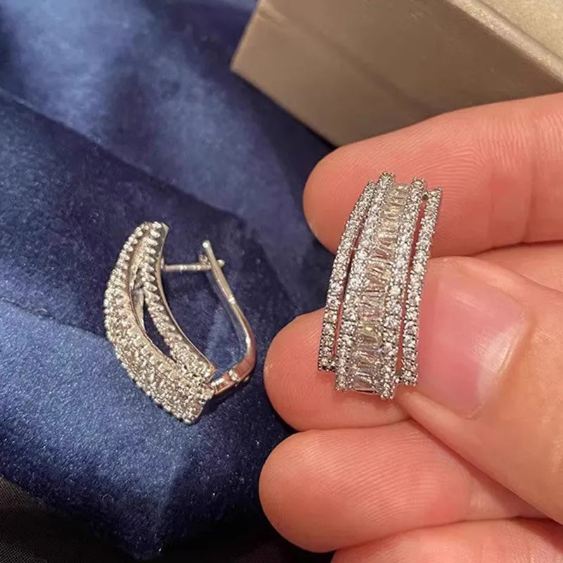 A pair of women's geometric stud earrings with inlaid zircon stones in a white gold colour finish.