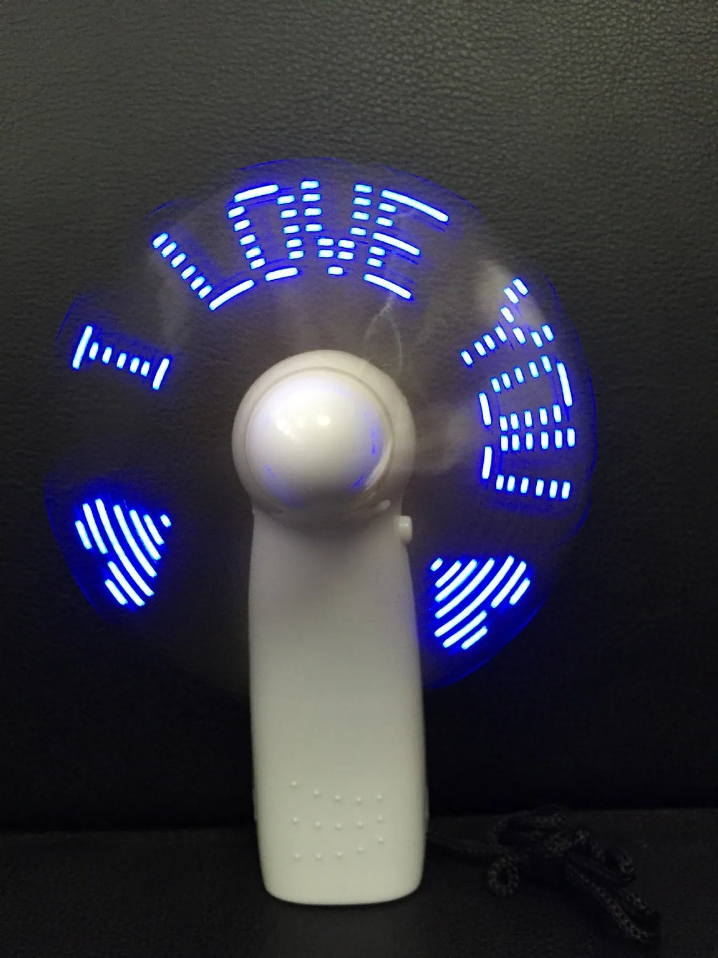 White handheld mini fan with LED love heart pattern display showing blue and red colours