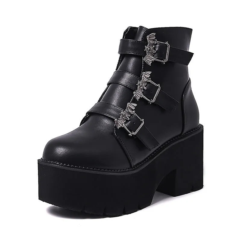 Black women's punk ankle boots with bat buckle detail, chunky heel, and side zipper.