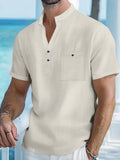 Man wearing a light blue stand collar linen short sleeve t-shirt with a loose fit.