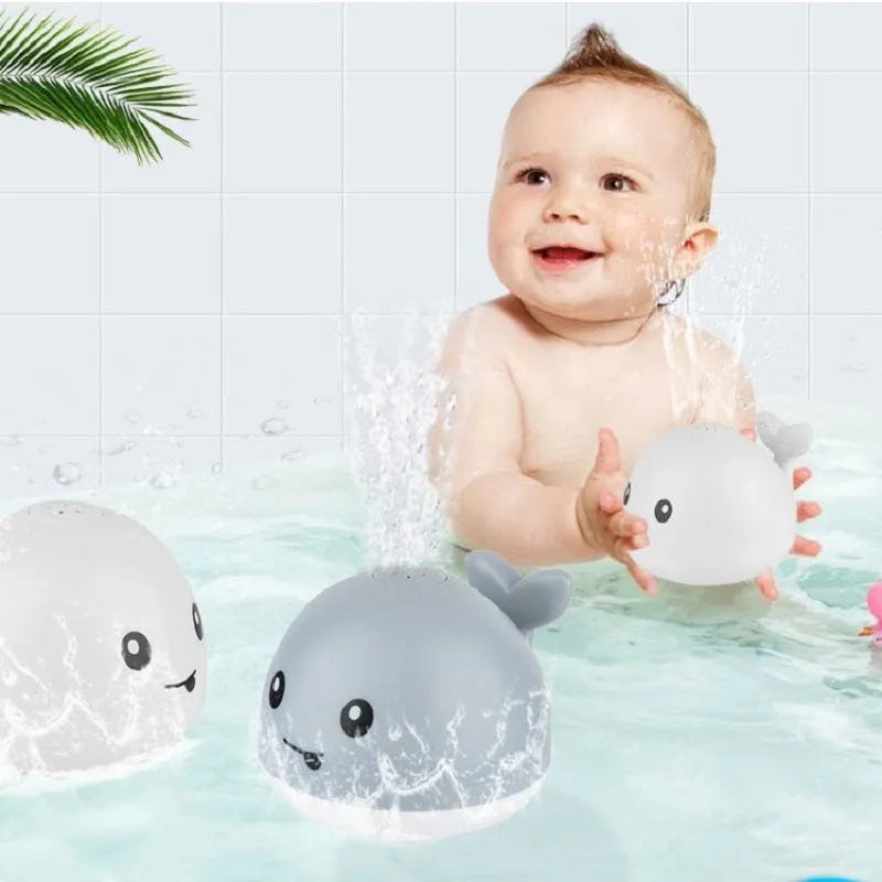 White and blue electric whale bath toy spraying water with flashing lights on base.