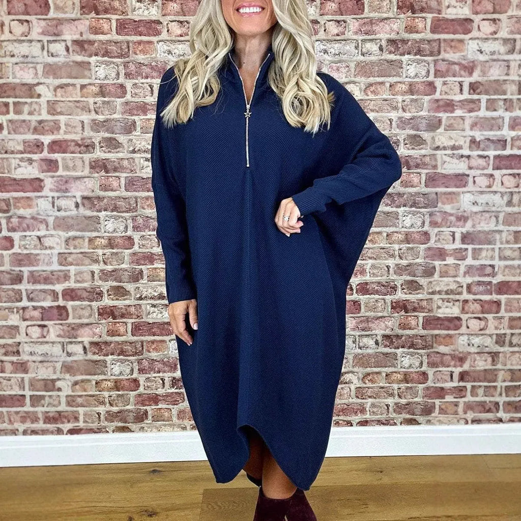 A woman's solid colour loose knit dress with raglan sleeves, shown on a hanger.