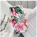 Pink floral pattern TPU back cover case for iPhone on a wooden table.