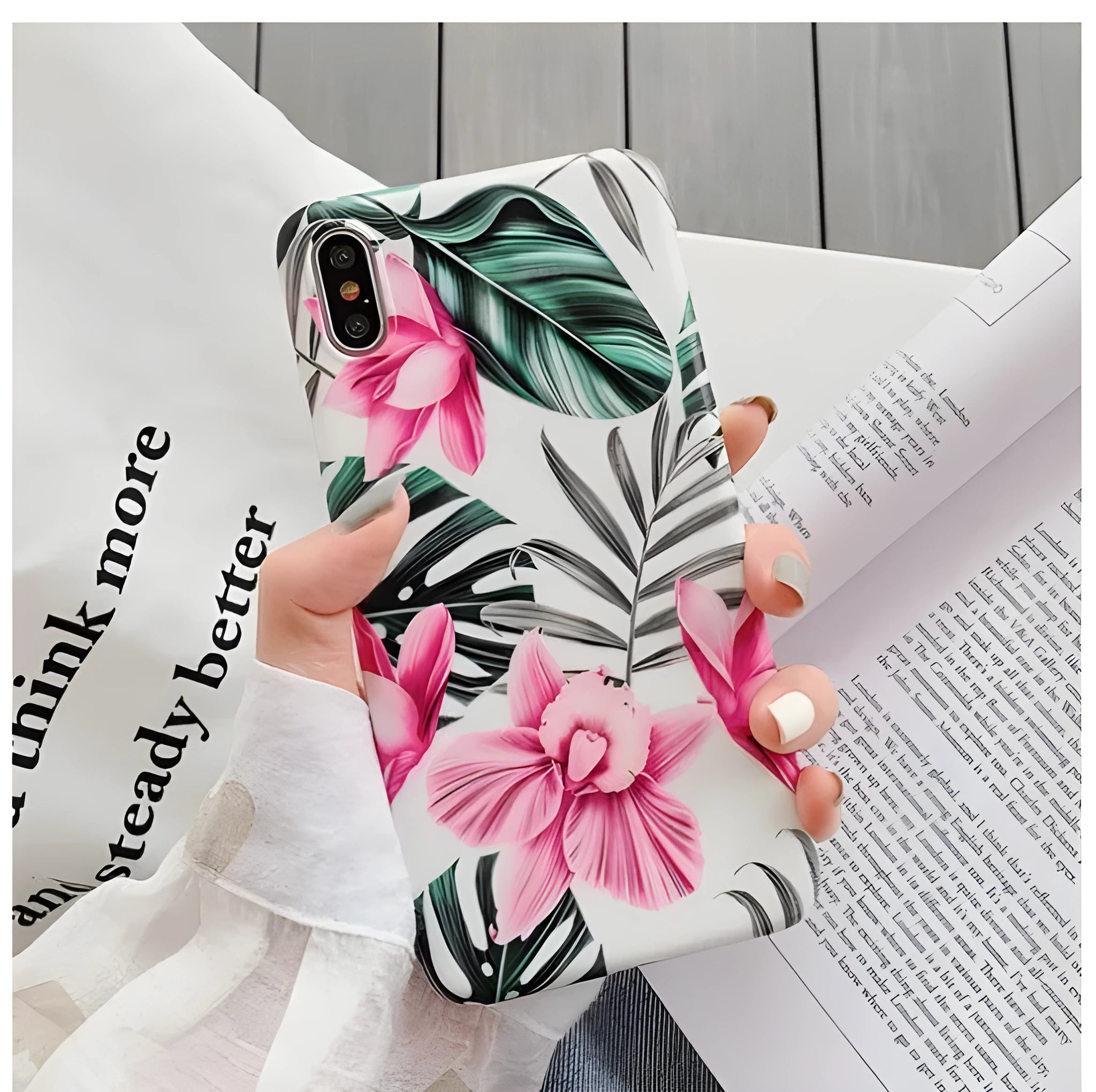Pink floral pattern TPU back cover case for iPhone on a wooden table.