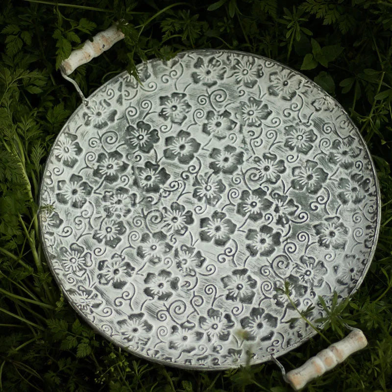 Round wrought iron storage trays in two sizes on a wooden surface