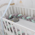 Braided knot baby crib bumper in spandex velvet, shown in light grey colour, flexible and bent to shape.