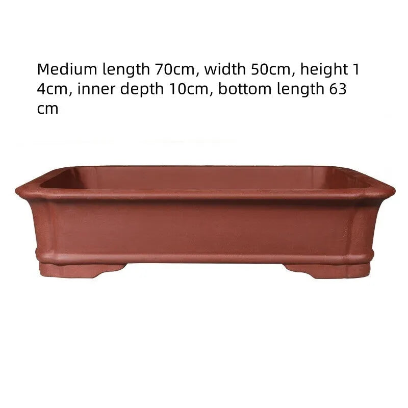 Large rectangular purple clay bonsai pot shown outdoors, highlighting its handmade texture and substantial size.