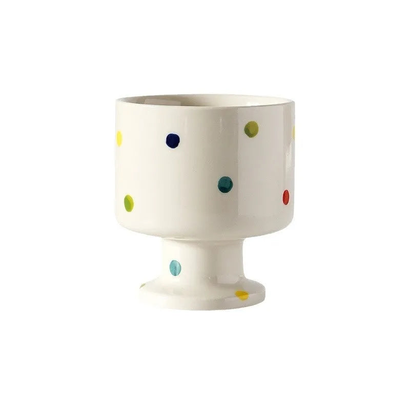 Hand-pinched irregular shaped ceramic mug in a solid colour, shown on a surface.