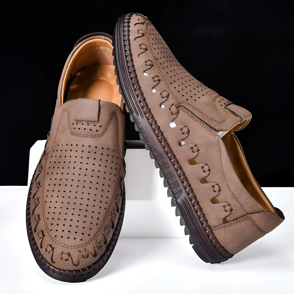 Men's brown leather slip-on casual shoes with flat sole, round toe, and decorative stitching.