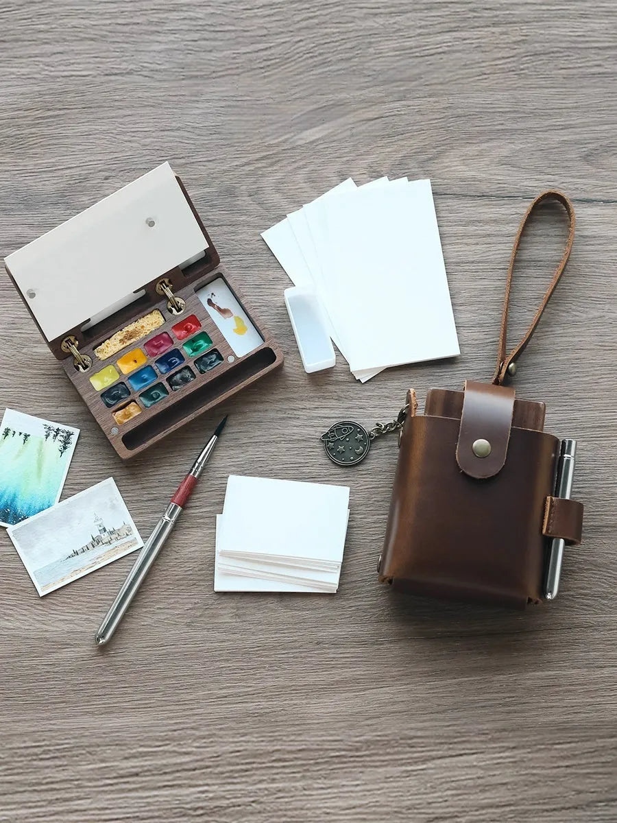 Mini wooden watercolour paint box with walnut finish, showing closed lid.
