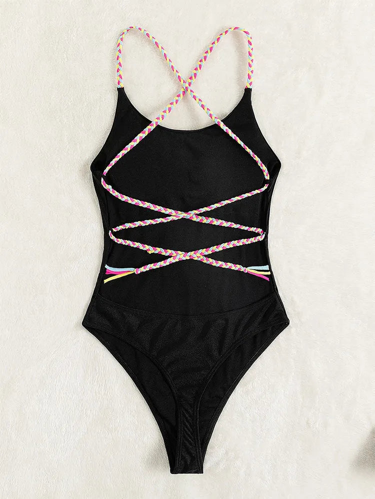 Black solid colour backless one-piece swimsuit for women on a hanger.