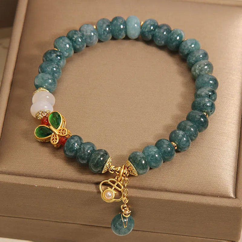 Blue jade abacus bead bracelet with alloy inlay and rhinestone decoration showing butterfly and white agate elements