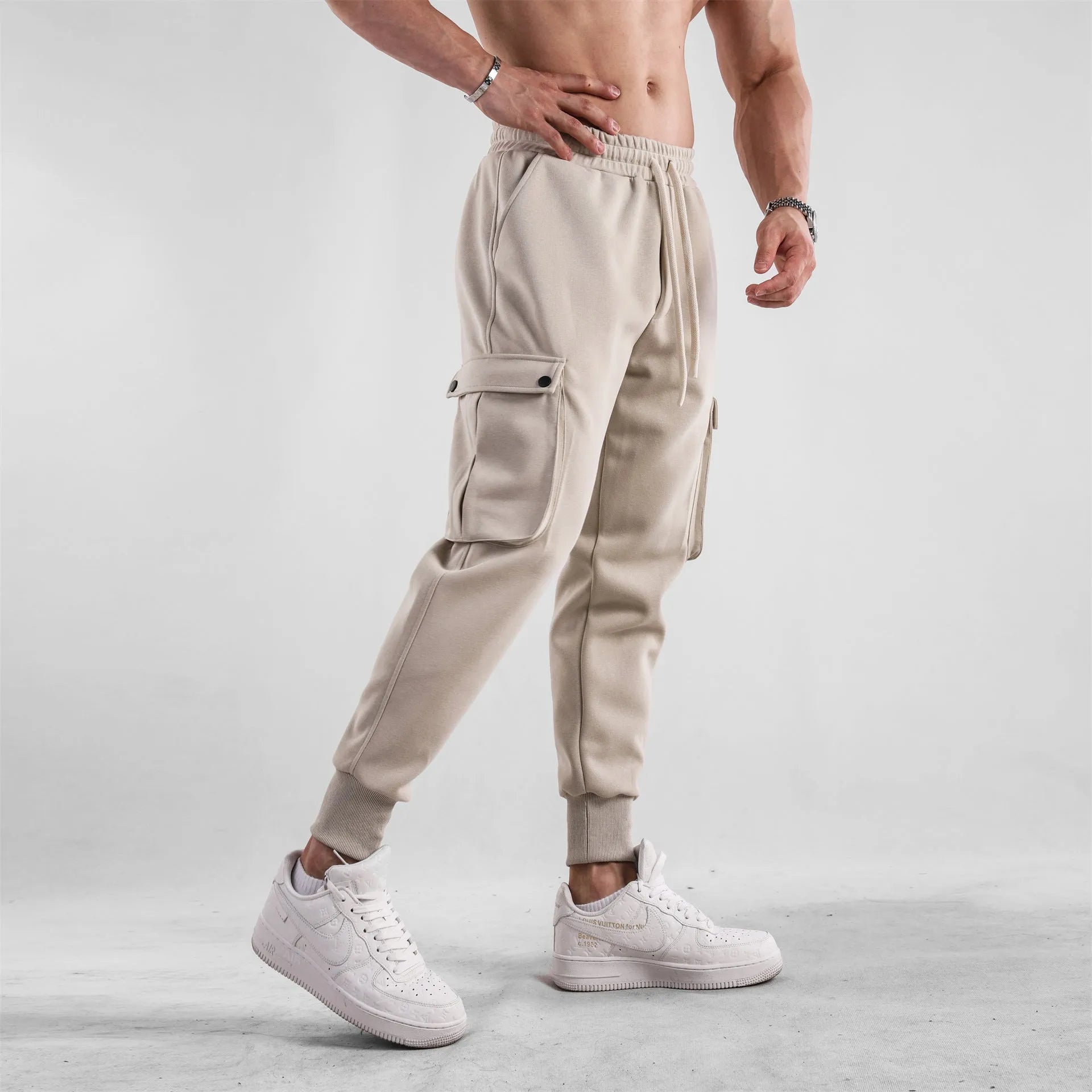 Men's loose cotton trousers with ankle ties and multiple pockets in a light grey colour