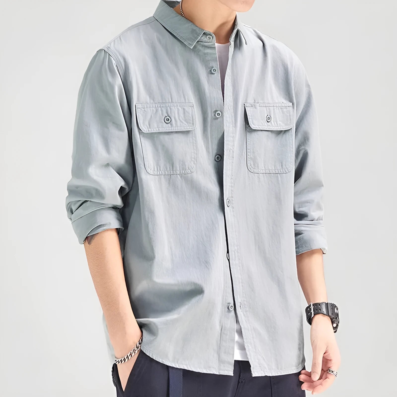 Man wearing a loose-fit grey long sleeve cardigan-style shirt, showcasing its relaxed silhouette and polyester material.