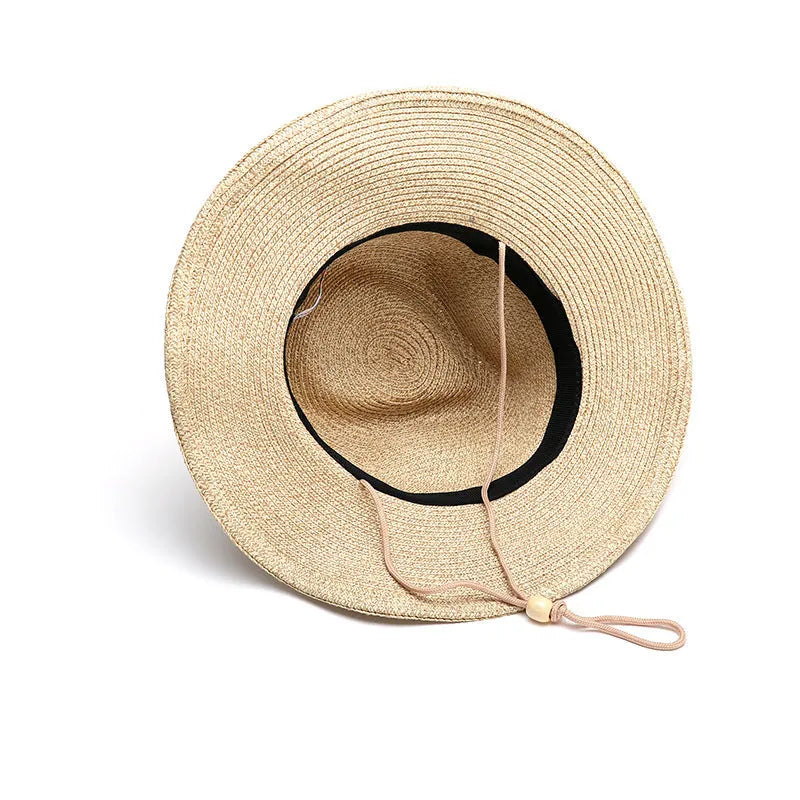 Men's foldable wide brim straw sun hat in beige, shown in a travel context.