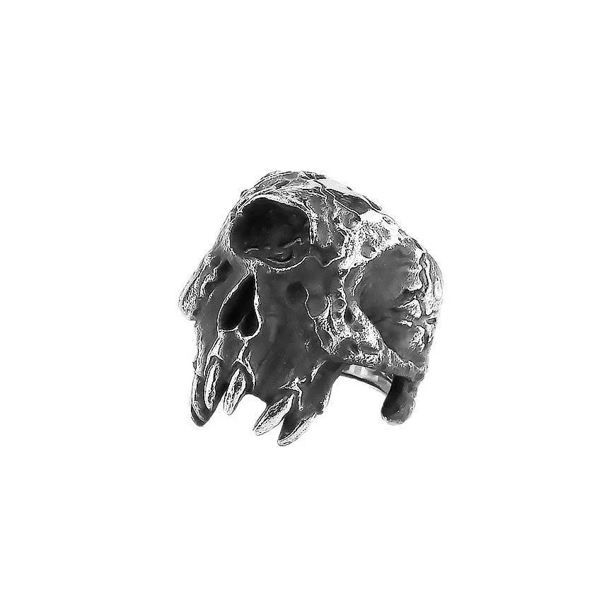 Close-up of a silver-toned alloy ring with a detailed one-eyed skull design on a black background.