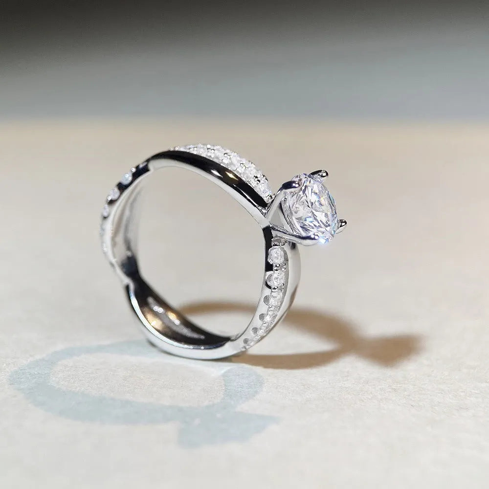 Geometric twisted silver-coloured band moissanite ring with a 1 carat stone in a four-claw setting.