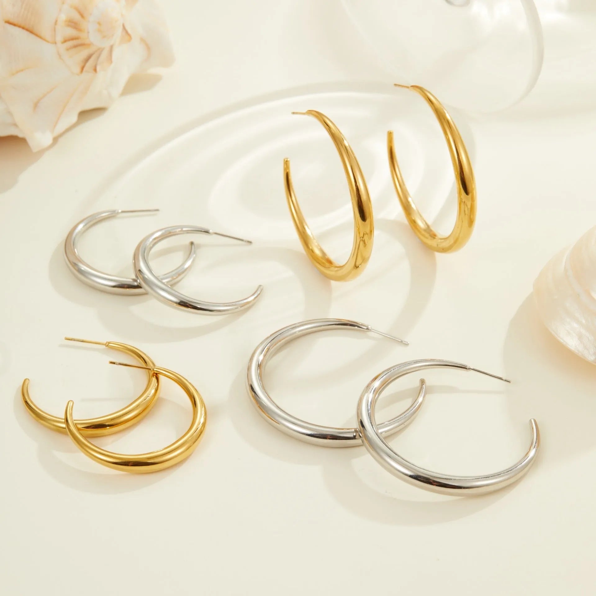 Titanium steel hoop earrings in geometric round design with gold and steel finish options