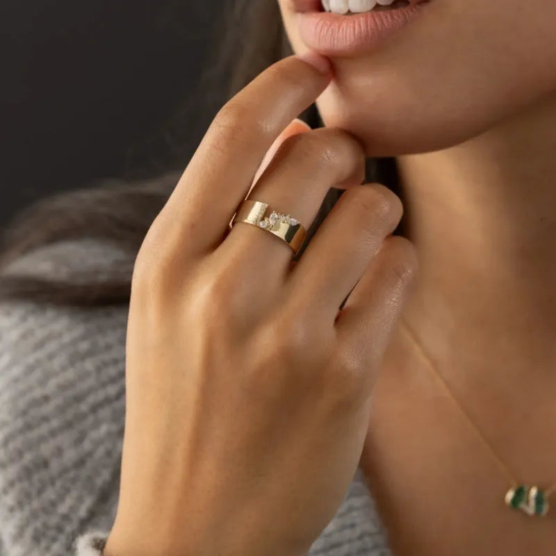 Gold electroplated women's ring with zircon detail on a copper band, showing sizing options.